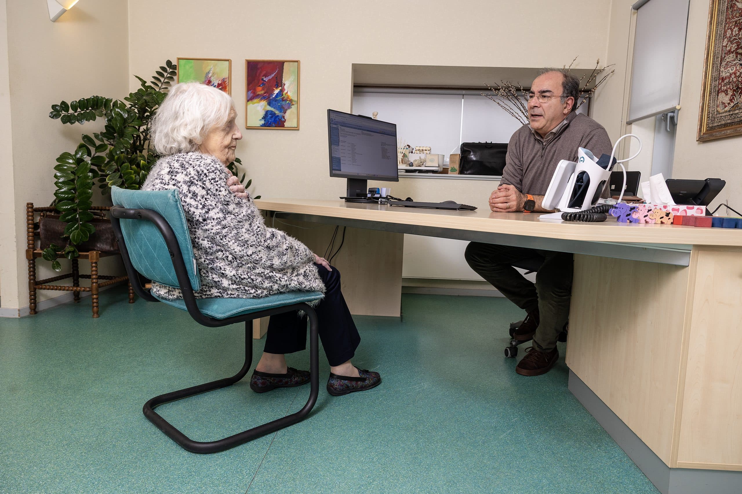 Huisarts en oudere patiënt in gesprek